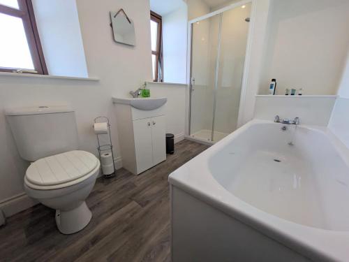 威克2 Bedroom Townhouse with Seaview on the NC500 Wick的浴室配有卫生间、浴缸和水槽。