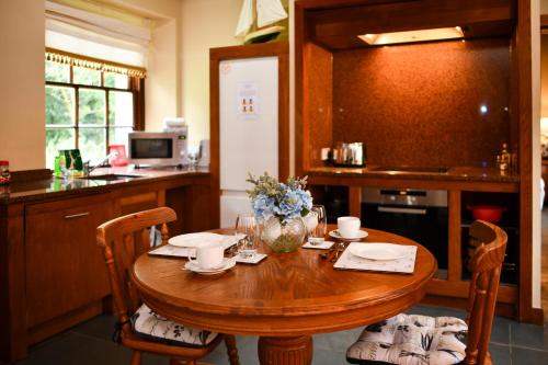 MayboleCloncaird Castle Estate Cottages的厨房配有木桌和鲜花椅子