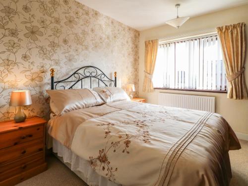 奥尔弗里顿Hideaway的一间卧室设有一张大床和一个窗户。