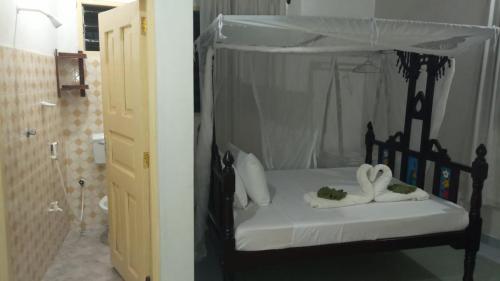 拉穆Manama Suites Lamu的一间卧室配有一张带毛巾的黑色床