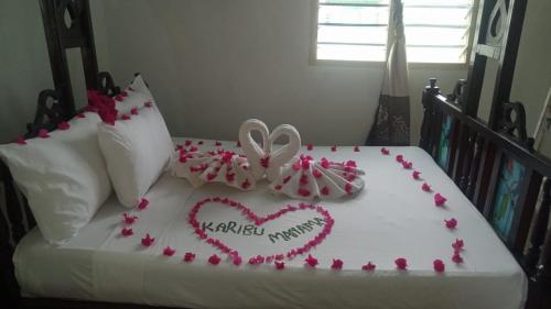 拉穆Manama Suites Lamu的一张有两颗心和鲜花的床