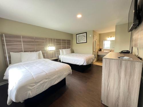 桑蒂Travelodge by Wyndham Santee的酒店客房配有两张床和一张书桌