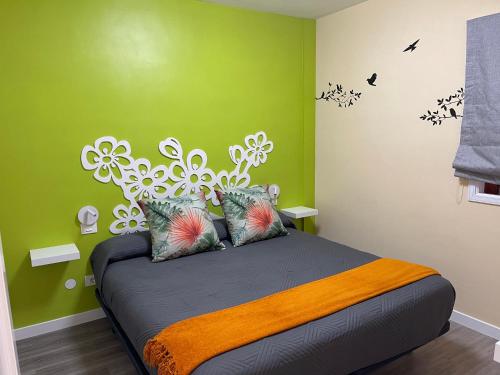 加拉奇科Vv La Joya Del Mar Suites的一间卧室设有一张带绿色墙壁的大床