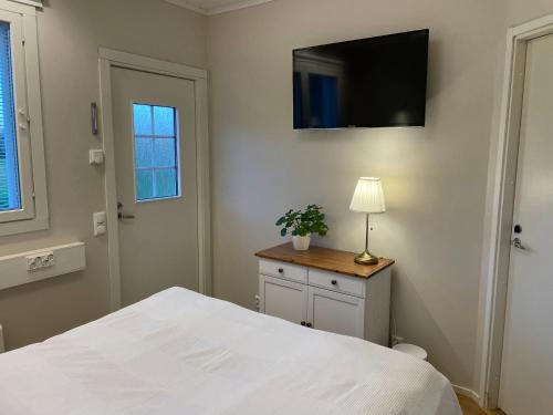 Puuppola Kotikoivu的卧室配有白色的床和墙上的电视