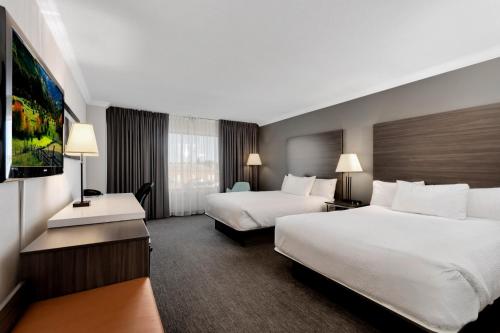 里贾纳The Atlas° Hotel的酒店客房设有两张床和电视。