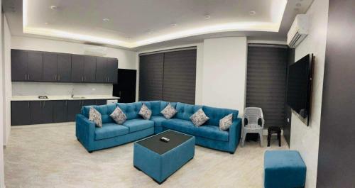 Al RamaThe Mansion villa的一间带蓝色沙发的客厅和一间厨房
