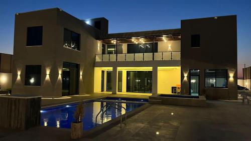Al RamaThe Mansion villa的一座房子前面设有游泳池