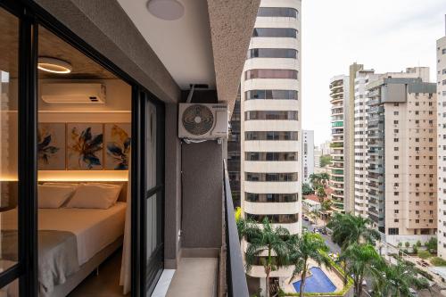 戈亚尼亚Lindos apto com piscina no Setor Oeste IDV的卧室,位于阳台,与大楼相连