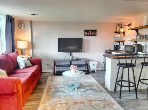 温尼伯Cozy Private Suite的一间带红色沙发的客厅和一间厨房