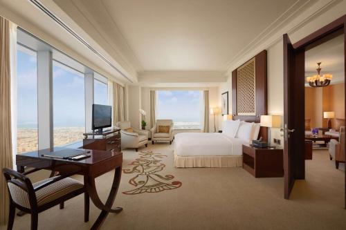 迪拜迪拜康莱德酒店的酒店客房配有一张床、一张书桌和一台电视。