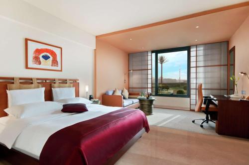 科威特科威特希尔顿度假酒店的一间大卧室,配有一张大床和一张书桌