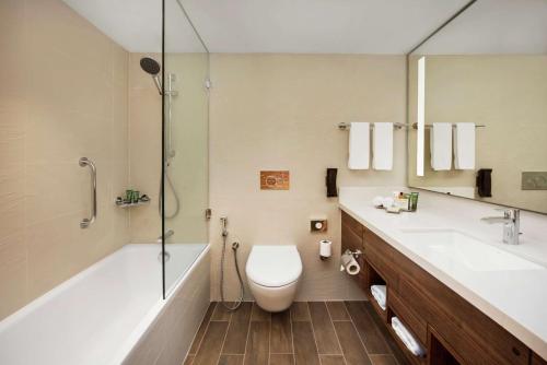 拉斯阿尔卡麦希尔顿哈伊马角酒店的浴室配有卫生间、浴缸和水槽。