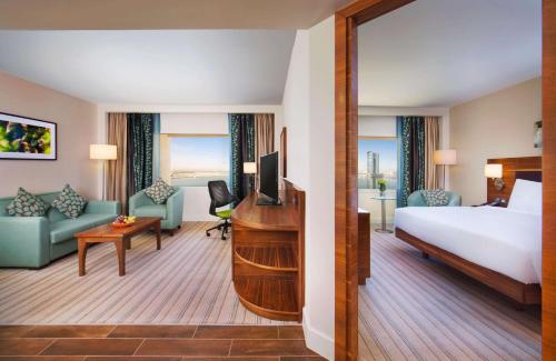 拉斯阿尔卡麦希尔顿哈伊马角酒店的配有一张床和一张书桌的酒店客房