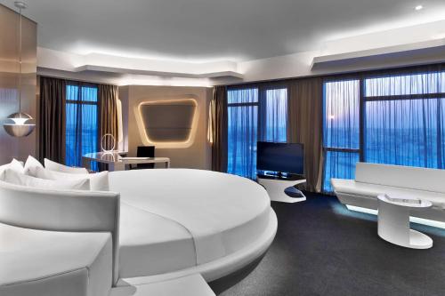 迪拜迪拜V希尔顿格芮酒店的卧室配有一张白色大床和电视。