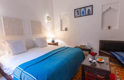 马拉喀什索斯贝皮尔摩洛哥传统庭院住宅的一间卧室配有一张带蓝色毯子的大床