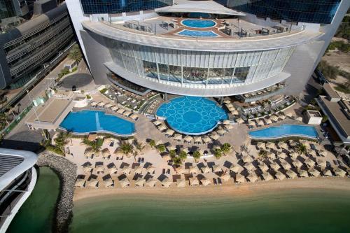 阿布扎比Conrad Abu Dhabi Etihad Towers的享有带游泳池和大楼的度假村的空中景致