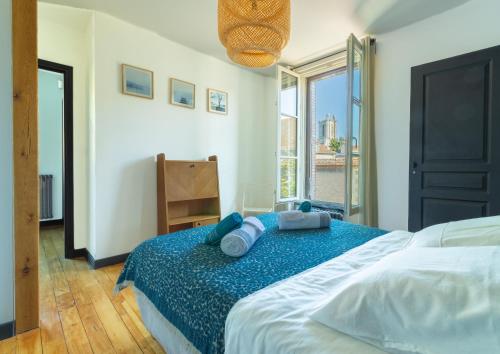 特鲁瓦Le Cordelier - Jardin en plein centre - Quais de Seine的一间卧室配有一张大床和蓝色枕头