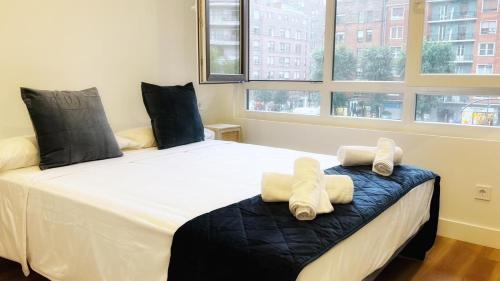 毕尔巴鄂Deustown Apartamentos的一间卧室配有一张大床和毛巾