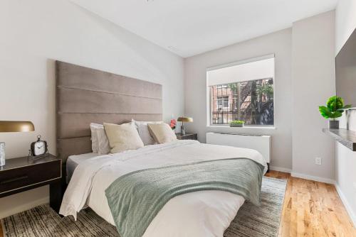 纽约Unbeatable 3BR with Private Patio in Upper East Side的一间卧室设有一张大床和一个窗户。