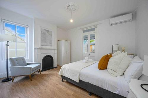 悉尼Victorian Dream Terrace CBD的一间卧室配有一张床、一把椅子和一个壁炉