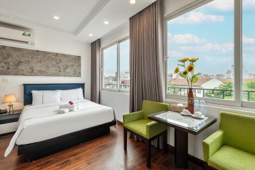 河内Golden Sun Hotel的卧室配有一张床和一张桌子及椅子