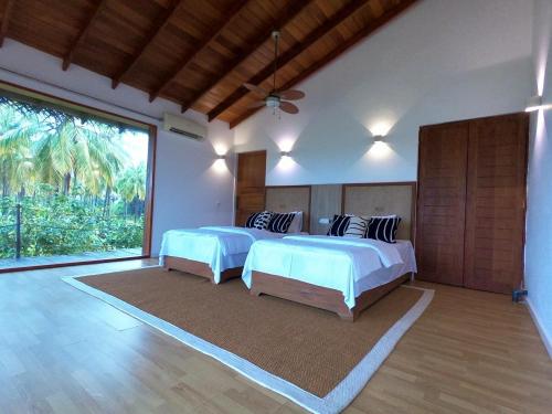 帕西库达Vandalous Bay的一间卧室设有两张床和大窗户