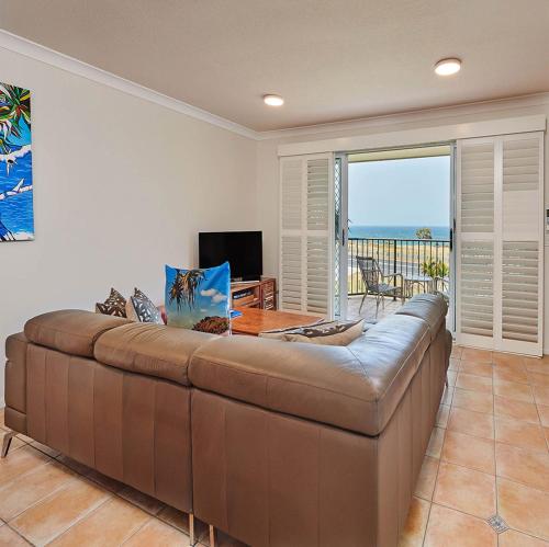 卡巴雷塔海滩Cabarita Beachfront Apartments by Kingscliff Accommodation的客厅设有一张大棕色沙发,享有海景