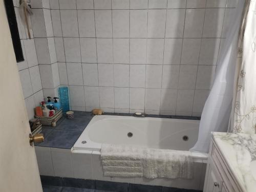 瓦尔帕莱索Casa del Limón的浴室设有白色瓷砖墙,配有白色浴缸。