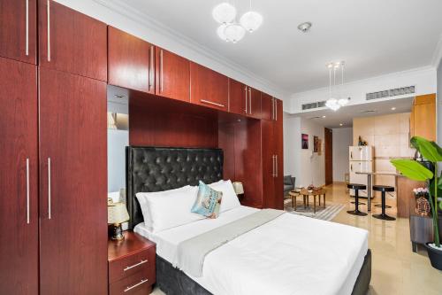 迪拜Furnished Apartment For Rent In Saba 3, Jlt的一间卧室配有一张大床和木制橱柜。