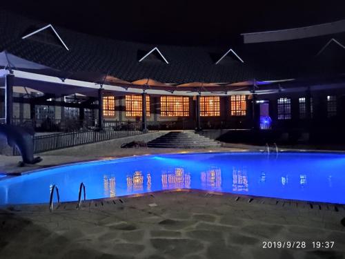 马查科斯Kiikalloh Grand Resort的一座晚上设有游泳池的建筑