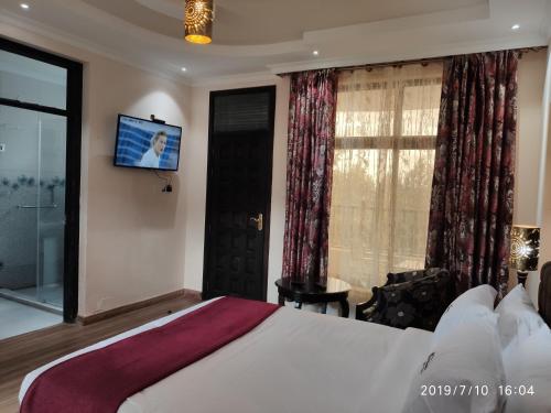 马查科斯Kiikalloh Grand Resort的酒店客房设有一张床和墙上的电视