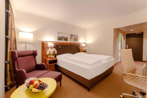 维也纳PLAZA Premium Wien的配有一张床和一把椅子的酒店客房