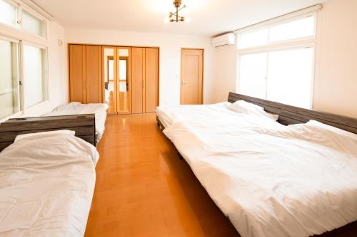 函馆Villa Futaba若松町的配有白色床单的客房内的两张床