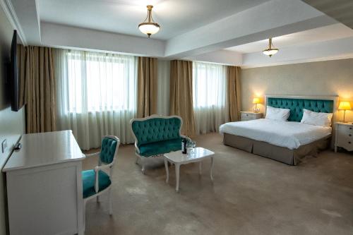 罗曼Hotel Roman by Dumbrava Business Resort的酒店客房带一张床、一张桌子和椅子