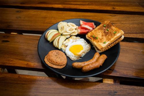 大吉岭Trippers hostel的包括鸡蛋香肠和烤面包的早餐食品