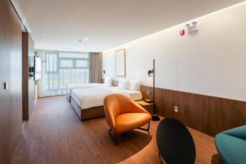 始兴市Hotel Cielo的配有一张床和一把椅子的酒店客房