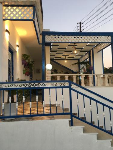 乌姆盖斯بيت العُمري (ام قيس)的楼梯上有一个蓝色栏杆的房子