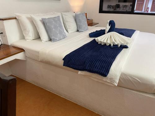 莫阿尔博阿莫阿尔博阿度假村的一张带蓝色和白色枕头的床,床上有天鹅