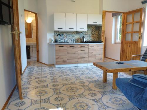 SmolarniaSmolarnia的厨房配有白色橱柜和桌子,铺有瓷砖地板。