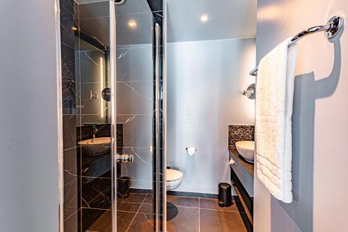 汉堡NYX Hotel Hamburg by Leonardo Hotels的一间带玻璃淋浴和卫生间的浴室