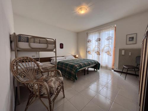 GiustinoAPPARTAMENTO PANORAMA 016的一间卧室配有一张床、一张床和一把椅子