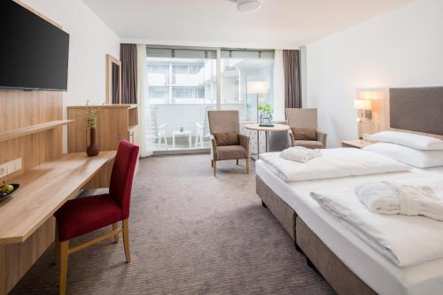 巴特基辛根Hotel Frankenland的酒店客房配有两张床和一张书桌
