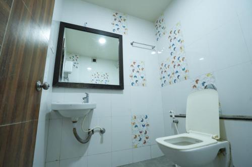 戈尔哈布尔Hotel Anand的一间带卫生间、水槽和镜子的浴室