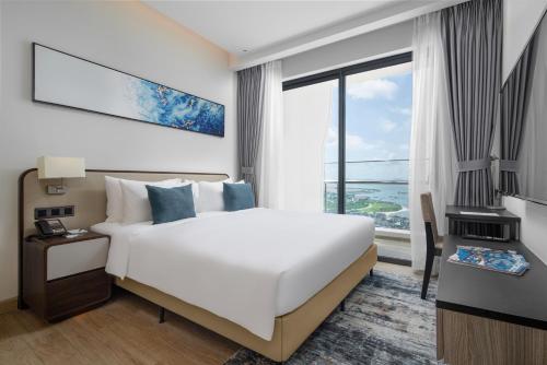下龙湾Citadines Marina Halong的一间卧室设有一张大床和一个大窗户