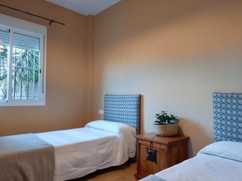 UmbreteLas Villas - Chalet y Piscina a 10´de Sevilla的客房设有两张床和窗户。