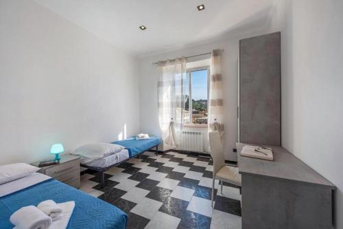 热那亚casa vacanza Laura的客房设有两张床、一张桌子和一个窗户。