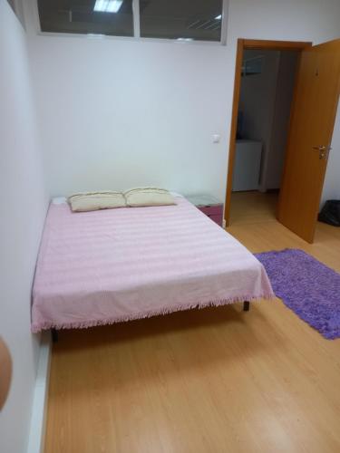 莱里亚Centro Leiria的一间卧室配有一张带紫色毯子的床