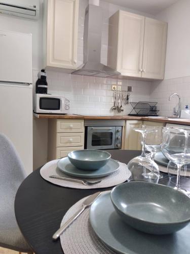 瓦伦西亚Apartamento delux2的厨房配有带盘子和玻璃杯的桌子