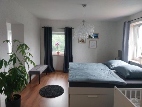 DürrhennersdorfHaus am Seidelberg的一间卧室配有一张床和盆栽植物