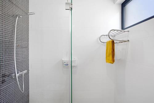圣港Recanto Dourado的玻璃门淋浴,带黄毛巾